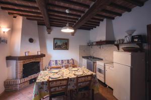 cocina con mesa con sillas y chimenea en Nature & Relax in Tuscany - Pagiano 2, en Roccastrada