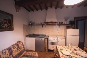 cocina con fogones blancos horno superior junto a una mesa en Nature & Relax in Tuscany - Pagiano 2, en Roccastrada