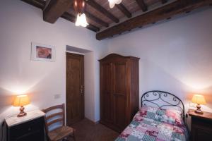 1 dormitorio con 1 cama, armario y mesa en Nature & Relax in Tuscany - Pagiano 2, en Roccastrada