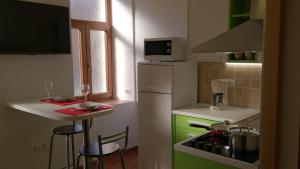 a small kitchen with green cabinets and a white refrigerator at Apartment Studio Prima in Rijeka