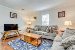a living room with a couch and a tv at Charming Satsuma Home about 14 Mi to Mobile! in Saraland