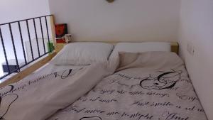 a bed covered with sheets with writing on it at Apartment Studio Prima in Rijeka