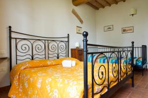 a bedroom with a black bed with an orange blanket at Tenuta Il Casale di San Miniato in San Miniato