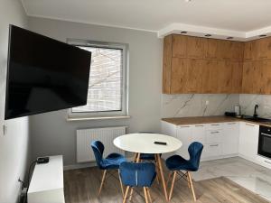 a kitchen with a table and chairs and a tv at Project Comfort Apartament Lazurowa 168/87 in Warsaw