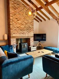 a living room with blue couches and a fireplace at The Wain House - A luxury countryside home for 6-8 near Ludlow in Ashford Carbonell