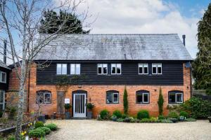 a brick house with a black roof at The Wain House - A luxury countryside home for 6-8 near Ludlow in Ashford Carbonell