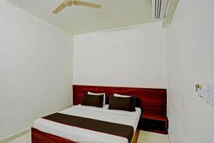 - une chambre avec un lit doté d'une tête de lit rouge dans l'établissement Super Collection O Hotel Aditya Inn, à Bhopal
