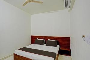 - une chambre avec un lit et une tête de lit en bois dans l'établissement Super Collection O Hotel Aditya Inn, à Bhopal