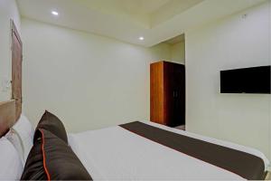 - une chambre avec un lit et une télévision à écran plat dans l'établissement Super Collection O Hotel Aditya Inn, à Bhopal