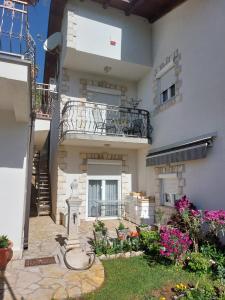 une maison avec un balcon et une cour fleurie dans l'établissement Kuća za odmor, à Žitomislići