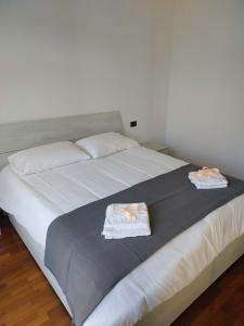 - un grand lit blanc avec 2 serviettes dans l'établissement HOUSE FIERA, à Bologne