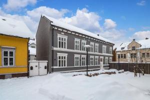 un edificio en la nieve con un edificio amarillo en Sentral leilighet med 4 soverom, en Tønsberg