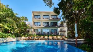 a hotel with a swimming pool in front of a building at Cristalino Lagoon Front Hotel, Restaurant & Spa in Bacalar