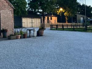 a gravel driveway with a table and potted plants at Owls Retreat, Meadowview House in Stoke on Trent