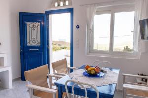 a dining room with a table with a bowl of fruit on it at Tinos Sunset Villa in Kékhros +27 photos