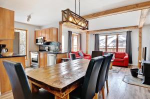a kitchen and living room with a wooden table and chairs at Chalets Alpins - 17 Chemin Alpin in Stoneham