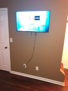 a flat screen tv hanging on a wall at Entire townhome available near nice park library and shopping in Winston-Salem