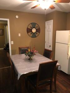 a dining room table with a clock on the wall at Entire townhome available near nice park library and shopping in Winston-Salem
