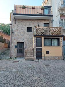 una casa de ladrillo con balcón en la parte superior en Borgo Gaggi p1 piano terra, en Gaggi