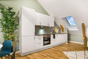 a kitchen with white cabinets and a skylight at Sentral leilighet med 4 soverom in Tønsberg