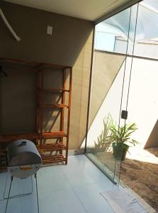 uma casa de vidro com uma cadeira e uma planta em Casa Luxo e Sossego 50m da Praia em Guriri