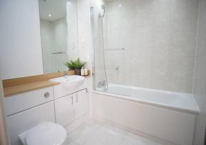 y baño con aseo, lavabo y ducha. en Excel - O2 Arena - 2 Bed Apartment Parking & Netflix, en Londres
