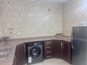 a kitchen with a washing machine and a refrigerator at Ibbin hospitality house 2 in Ajloun