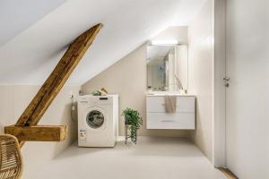 a laundry room with a washing machine and a sink at Sentral leilighet med 4 soverom in Tønsberg