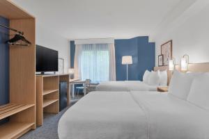 a hotel room with two beds and a flat screen tv at Spark by Hilton Orlando near SeaWorld in Orlando