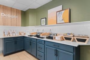 a kitchen with blue cabinets and a counter with pastries at Spark by Hilton Orlando near SeaWorld in Orlando