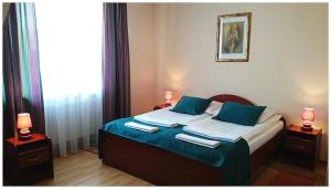 1 dormitorio con 1 cama con sábanas azules y 2 lámparas en GoGreen Hotel, en Rząska