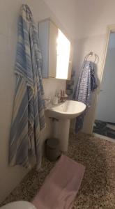 a bathroom with a sink and a toilet and a mirror at Alkisti's seaside apartments in Pythagoreio