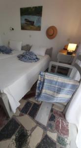 Habitación con 2 camas, mesa y lámpara. en Alkisti's seaside apartments, en Pythagoreio
