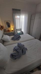 two beds in a small room with a window at Alkisti's seaside apartments in Pythagoreio