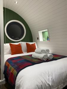 Luxury Glamping In North Yorkshire National Park & Coastal Area في سكرابورو: غرفة نوم مع سرير كبير مع وسائد ملونة