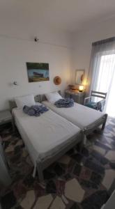 2 camas individuales en una habitación con ventana en Alkisti's seaside apartments, en Pythagoreio