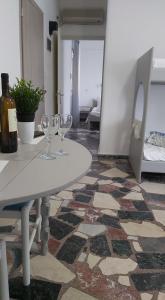 Alkisti's seaside apartments في بيثاغوريو: طاولة بيضاء مع كأسين من النبيذ عليها