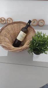 eine Flasche Wein in einem Korb neben einer Pflanze in der Unterkunft Alkisti's seaside apartments in Pythagoreio