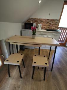 una gran mesa de madera con 2 bancos en la cocina en Glamping APARTMA NA KOZOLCU, 
