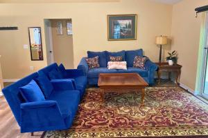 ein Wohnzimmer mit einem blauen Sofa und einem Tisch in der Unterkunft Sundance' Acres *Brand New House*with hot tub in Spring Hill