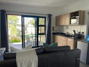 a living room with a couch and a kitchen at Nahoon Studio in East London