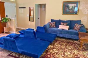 ein großes blaues Sofa im Wohnzimmer in der Unterkunft Sundance' Acres *Brand New House*with hot tub in Spring Hill