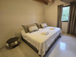 een slaapkamer met een bed met witte lakens en een raam bij La Velez in Guaymallen