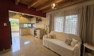 a living room with a white couch and a kitchen at La Velez in Guaymallen