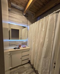 een badkamer met een douchegordijn en een wastafel bij La Velez in Guaymallen