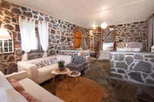 a living room with a stone wall at peaceful place in Anítsaion