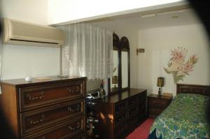 1 dormitorio con tocador, cama y espejo en Mare - Mare B, en Patra