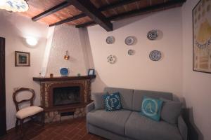 sala de estar con sofá y chimenea en Nature & Relax in Tuscany - Fresco 3, en Roccastrada