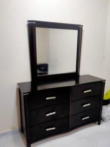 a dresser with a mirror on top of it at 1 BHK Fully Furnished Flat in Sharjah