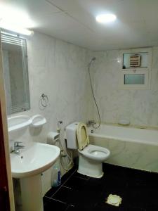 a bathroom with a white toilet and a sink at 1 BHK Fully Furnished Flat in Sharjah